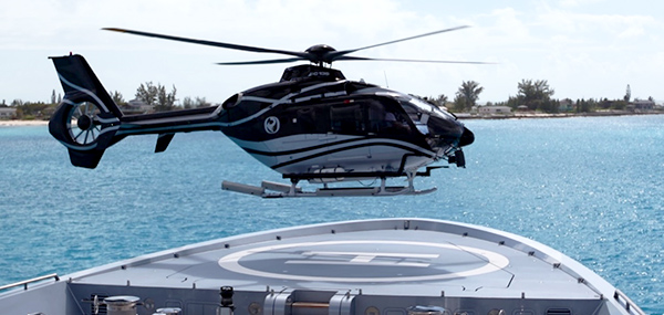 Helicopter landing on forward helideck of private superyacht