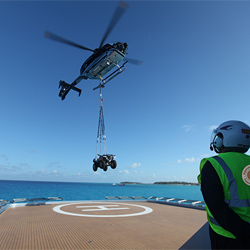 Helicopter lifting quad bike off luxury yacht